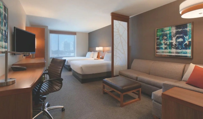 Quarto no Hyatt Place Chicago South com duas camas queen-size, mesa e sofá grande