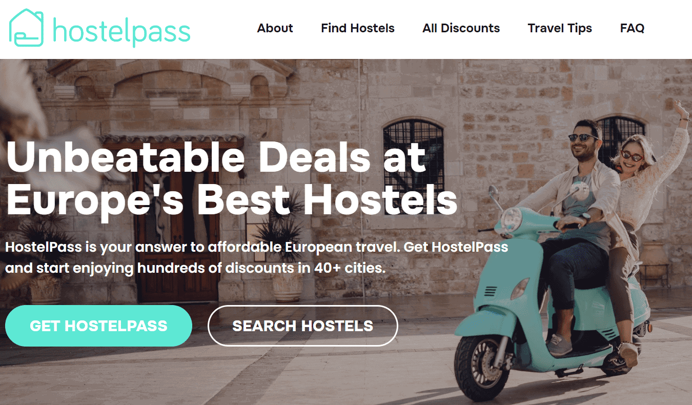Captura de tela da primeira página do site do HostelPass com um casal andando de Vespa por uma rua de paralelepípedos em algum lugar da Europa